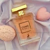 بطری 100 میل عطر زنانه کومو مویزل | Como Moiselle الحمبرا (مشابه شنل کوکو مادمازل) با طراحی شفاف و لوکس در پس‌زمینه‌ای مینیمال.