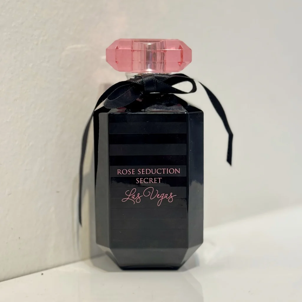 بطری 100 میل عطر زنانه ویکتوریا سکرت بامبشل نیویورک فرگرانس ورد با طراحی شیک و لوکس در پس‌زمینه‌ای مینیمال.